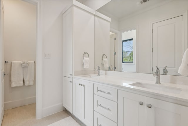 bathroom with double vanity and crown molding