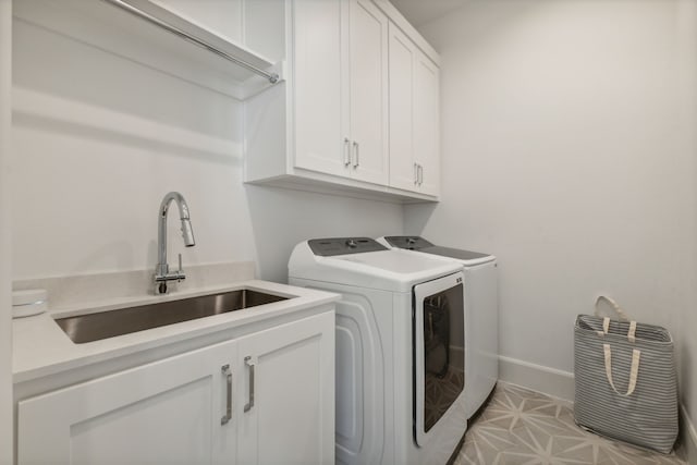 washroom featuring separate washer and dryer, sink, cabinets, and light tile floors