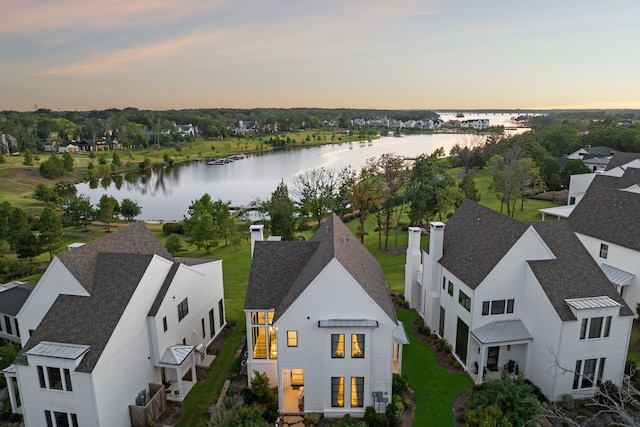 aerial view at dusk featuring a water view