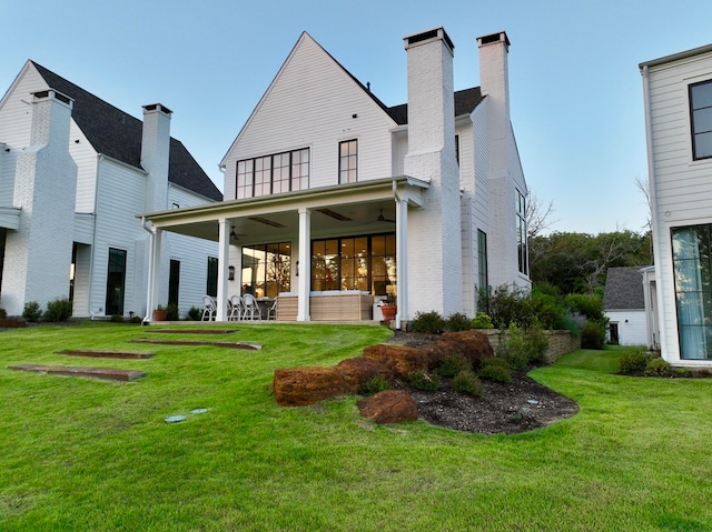 back of house with a lawn and ceiling fan