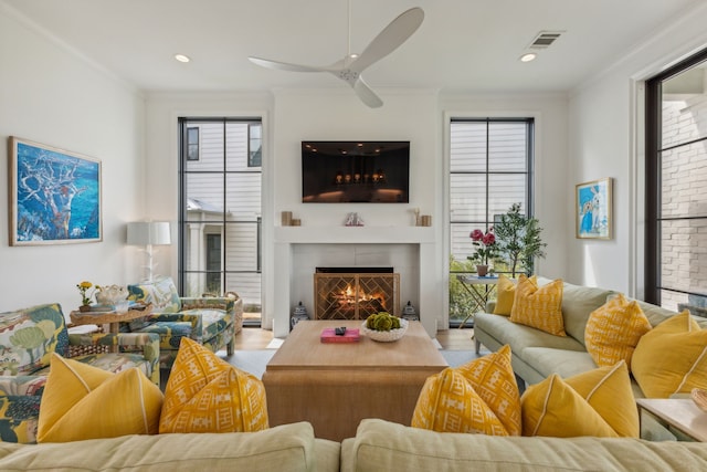 living room with ceiling fan and crown molding