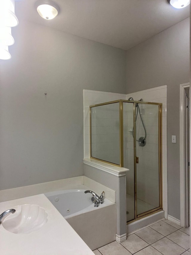 12308 Riviera Rd, Frisco, TX 75035 - bathroom with a jetted tub, baseboards, tile patterned floors, a sink, and a stall shower