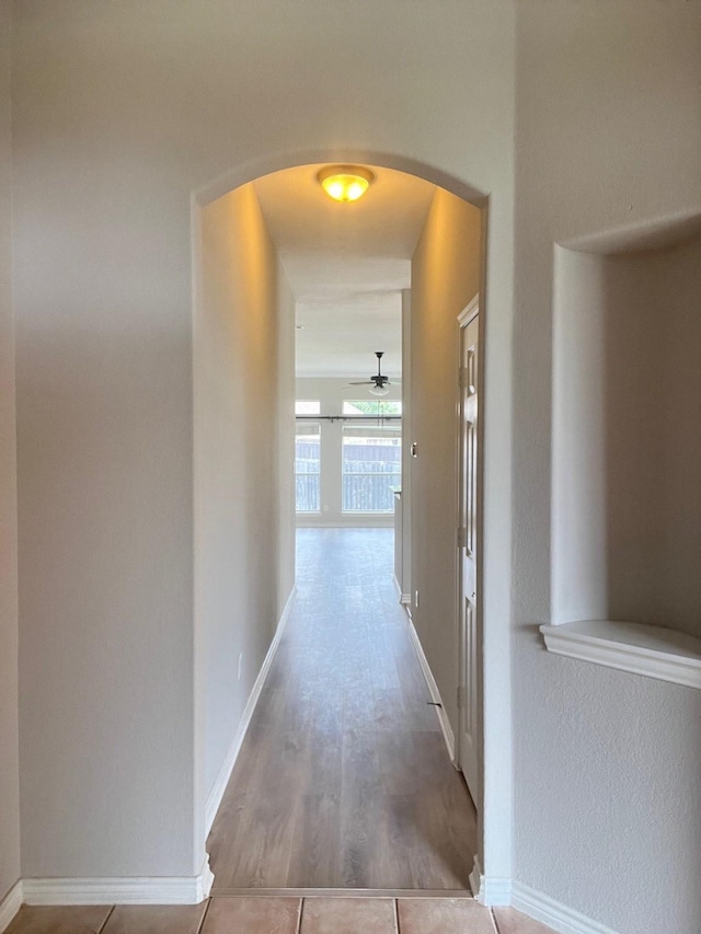 12308 Riviera Rd, Frisco, TX 75035 - hallway with arched walkways, baseboards, and wood finished floors