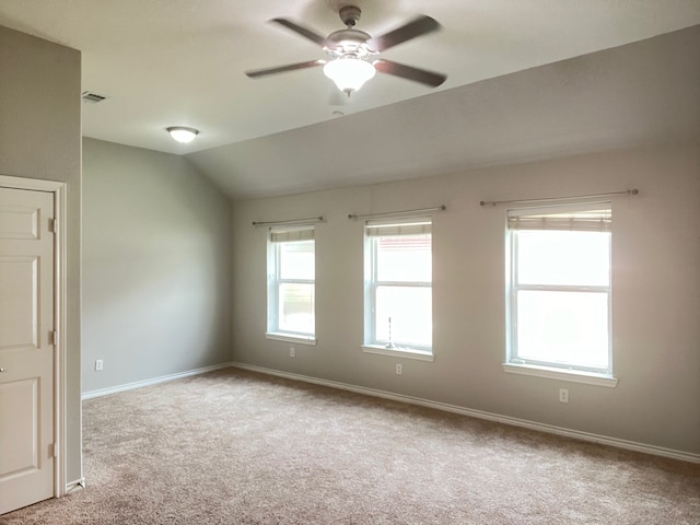 carpeted empty room with ceiling fan and vaulted ceiling