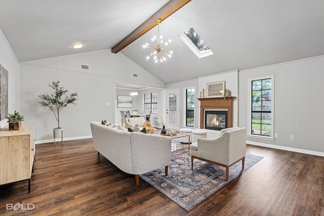 living room featuring lofted ceiling with skylight, dark wood-type flooring, a chandelier, and a fireplace