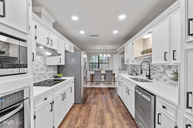 kitchen featuring white cabinets, sink, decorative light fixtures, appliances with stainless steel finishes, and a notable chandelier