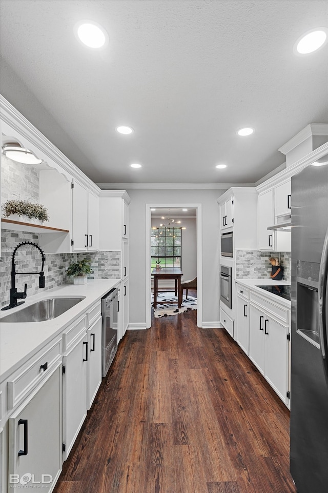 kitchen with white cabinetry, dark wood-type flooring, stainless steel appliances, crown molding, and sink