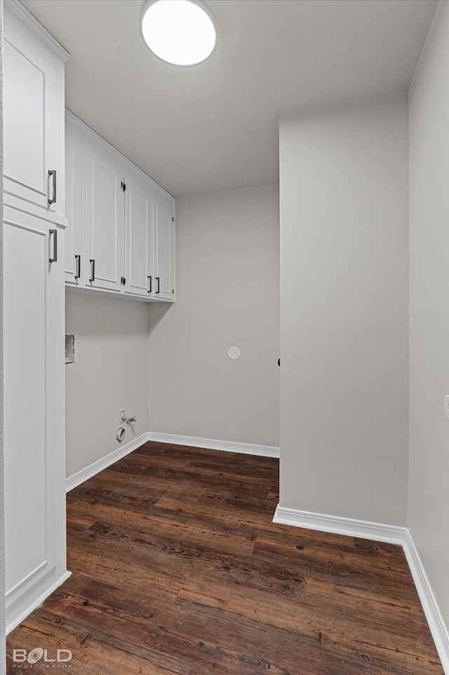 washroom featuring gas dryer hookup, cabinets, and dark wood-type flooring