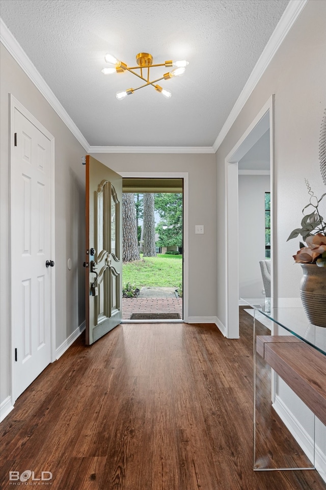 foyer entrance with a textured ceiling, ornamental molding, and dark hardwood / wood-style floors