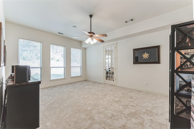 interior space with light carpet and ceiling fan