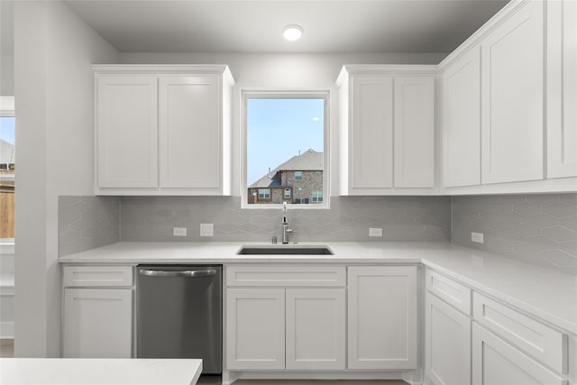 kitchen with white cabinetry, sink, decorative backsplash, and stainless steel dishwasher