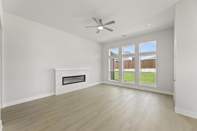 unfurnished living room featuring ceiling fan and light hardwood / wood-style flooring