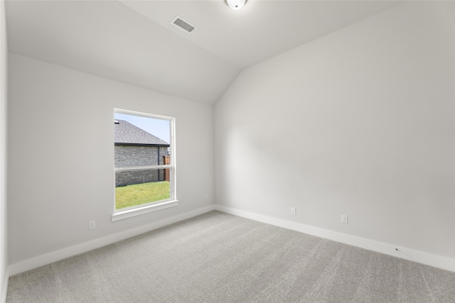 carpeted spare room featuring lofted ceiling