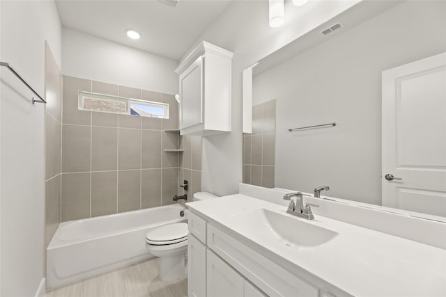 full bathroom with tile patterned flooring, toilet, tiled shower / bath, and vanity