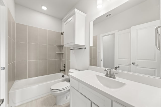 full bathroom featuring tiled shower / bath combo, tile patterned floors, toilet, and vanity