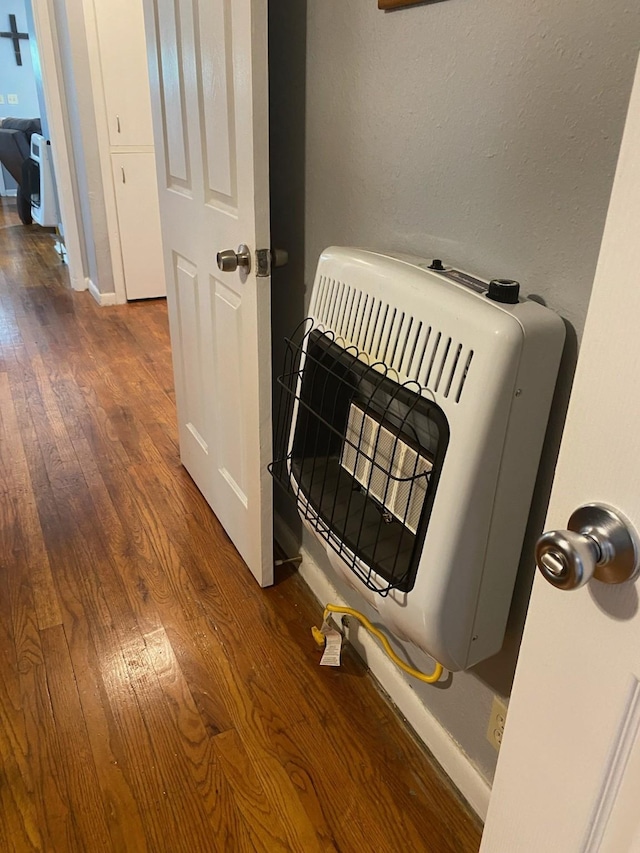 room details with heating unit and hardwood / wood-style flooring