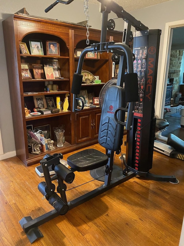 workout area featuring wood-type flooring and a textured ceiling