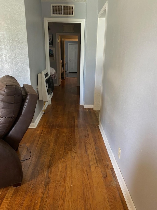 hallway featuring dark hardwood / wood-style floors and heating unit