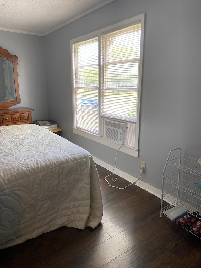 bedroom featuring a textured ceiling, dark wood-type flooring, and crown molding