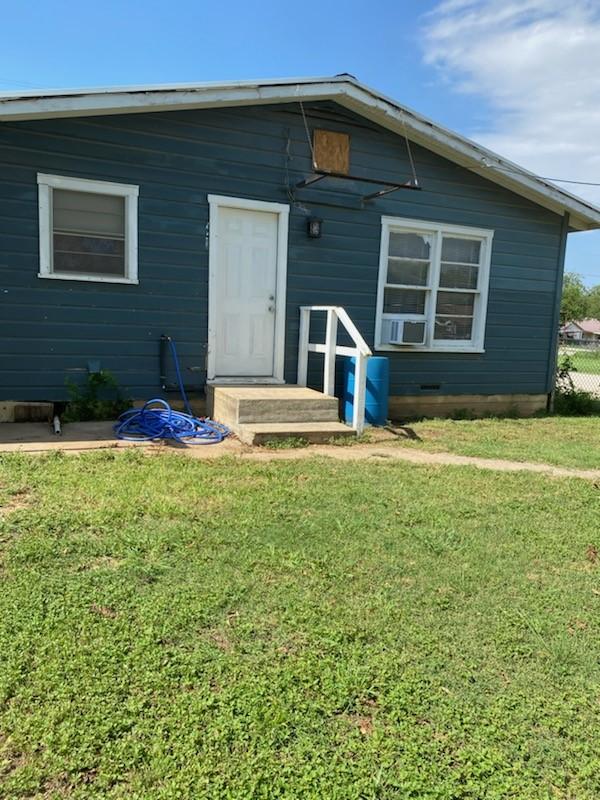 rear view of house featuring a yard