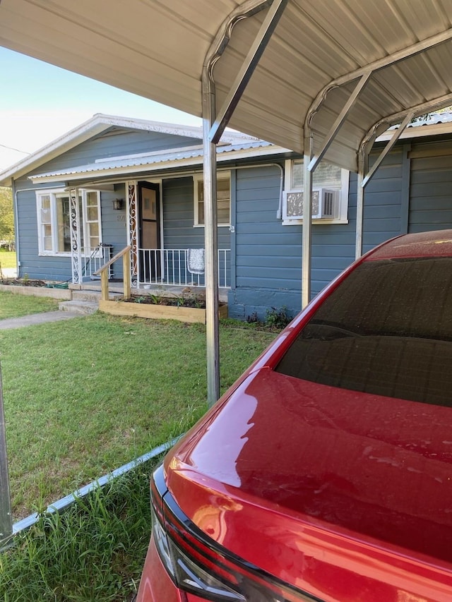 view of front facade with covered porch, a carport, and a front lawn