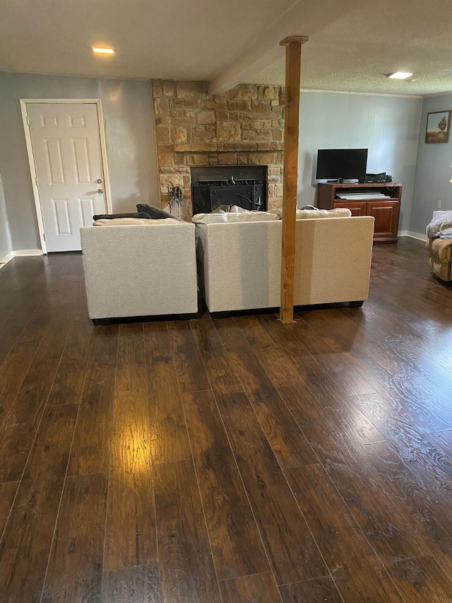 unfurnished living room featuring dark hardwood / wood-style flooring and a stone fireplace