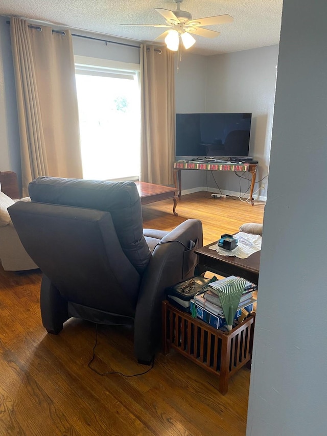 living room with wood-type flooring, a textured ceiling, and ceiling fan