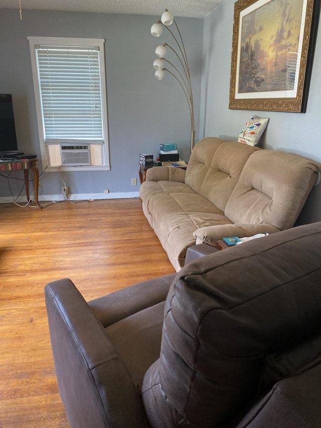 living room with hardwood / wood-style flooring, a textured ceiling, and cooling unit