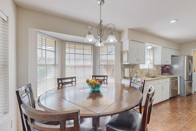 dining room featuring dark hardwood / wood-style flooring, sink, and a chandelier