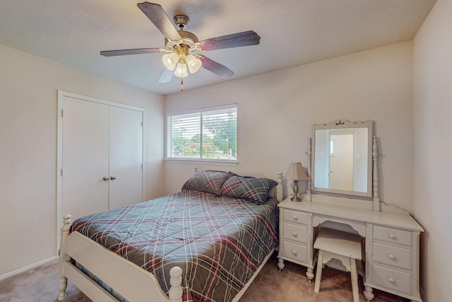 carpeted bedroom with ceiling fan and a closet