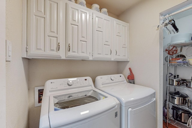 washroom featuring cabinets and washing machine and dryer