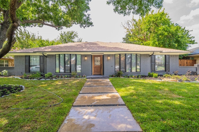 single story home featuring a front lawn