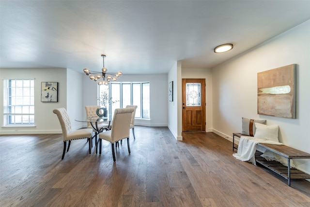 dining area featuring a healthy amount of sunlight, hardwood / wood-style flooring, and a chandelier