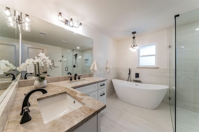 bathroom with shower with separate bathtub, dual bowl vanity, tile flooring, and tile walls