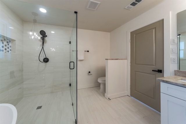 bathroom with walk in shower, vanity, and toilet