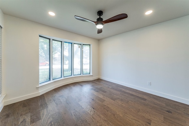 empty room with a wealth of natural light, ceiling fan, and dark hardwood / wood-style flooring