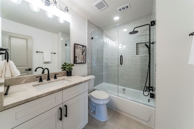 full bathroom with tile flooring, vanity with extensive cabinet space, toilet, and shower / bath combination with glass door