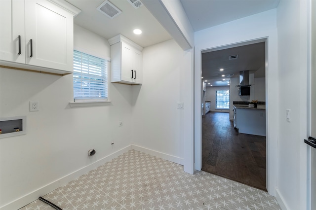 laundry room featuring cabinets, hookup for a washing machine, hookup for a gas dryer, and light hardwood / wood-style flooring