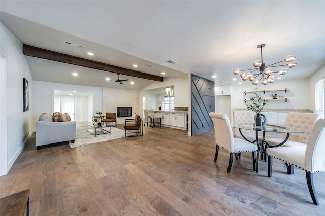 dining space with beamed ceiling, a chandelier, and wood-type flooring