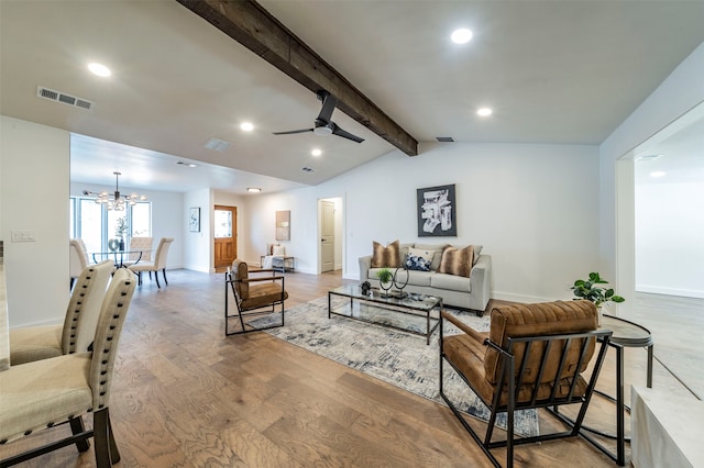 living room with ceiling fan with notable chandelier, vaulted ceiling with beams, and hardwood / wood-style flooring