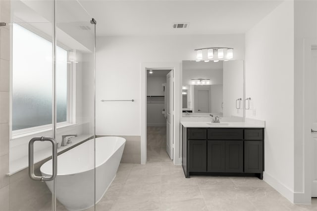 5241 Great Hollow Trl, Fort Worth, TX 76179 - bathroom featuring a soaking tub, vanity, a walk in closet, and baseboards