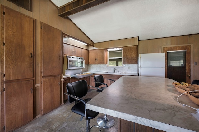 kitchen featuring tasteful backsplash, white fridge, lofted ceiling with beams, a textured ceiling, and sink