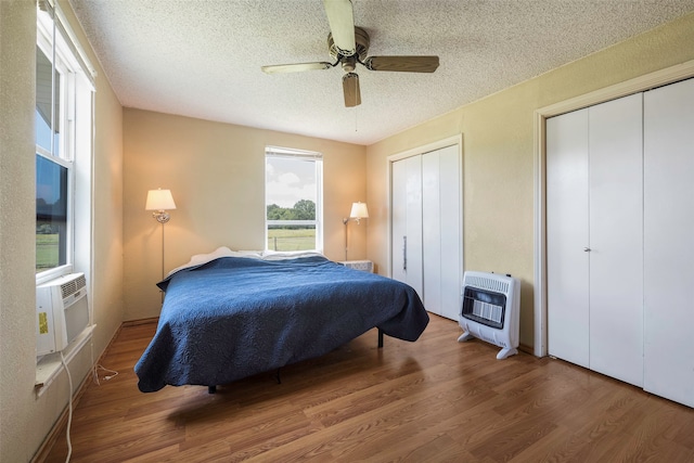 bedroom featuring multiple closets, ceiling fan, and hardwood / wood-style floors