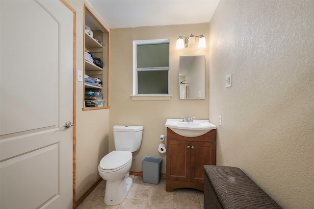 bathroom with tile flooring, toilet, and vanity