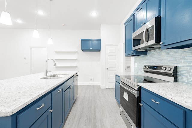 kitchen featuring stainless steel appliances, sink, a center island with sink, light hardwood / wood-style floors, and hanging light fixtures