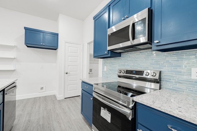 kitchen with blue cabinetry, light hardwood / wood-style floors, light stone counters, and stainless steel appliances