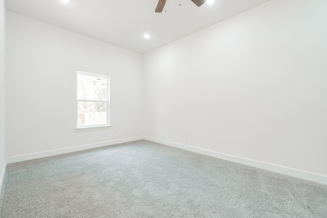 carpeted spare room with ceiling fan