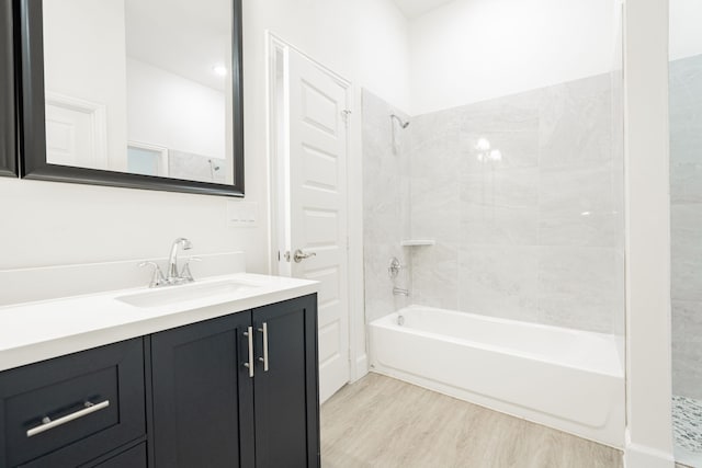 bathroom featuring hardwood / wood-style floors, vanity, and tiled shower / bath