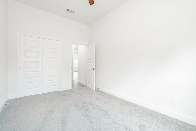 unfurnished bedroom featuring carpet flooring, ceiling fan, and a closet