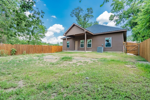 back of house with a lawn and central air condition unit